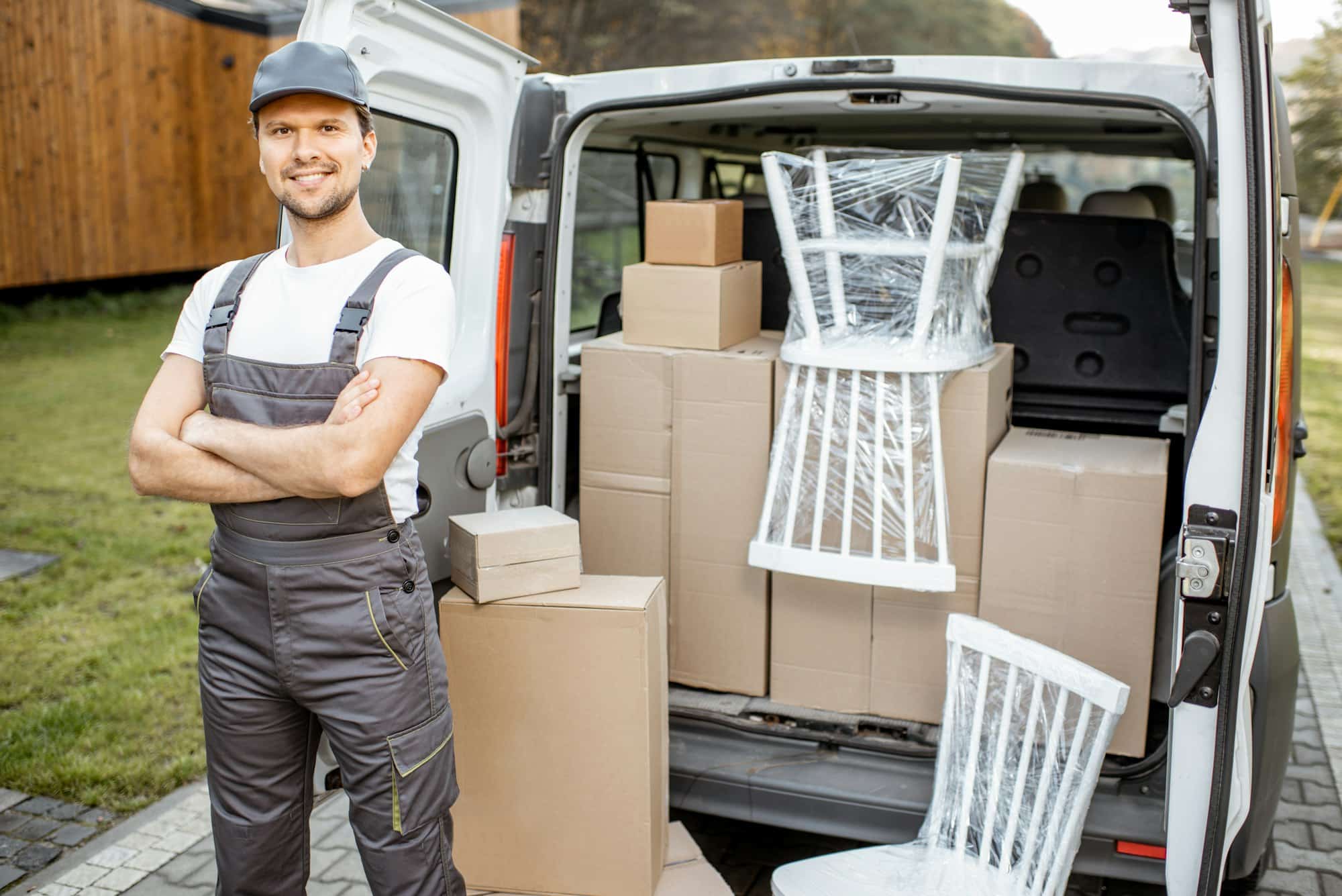 Handsome delivery man near the car trunk